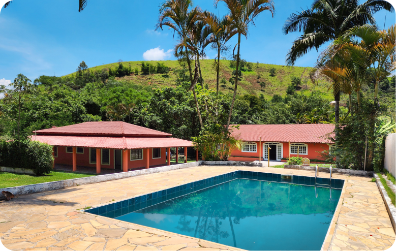 Piscina entre construções e jardim